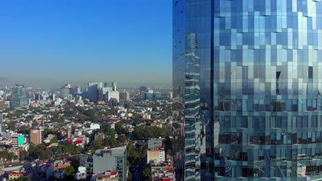 Drone-flying-in-front-a-tall-building-reflection-on-windows-urban-landscape-Mexico-city