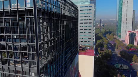 Drohne-Schwenkt-Wolkenkratzer-In-Mexiko-Stadt,-Reforma-Avenue-Bäume