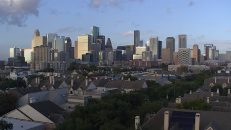 Establishing-aerial-shot-of-homes-and-downtown-Houston,-Texas-in-the-background