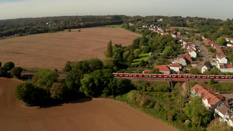 Aerial-profile-shot-of-London-underground-train-leaving-Epping-town
