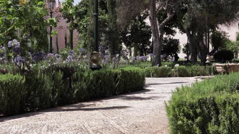 Jardín-Kasbah-En-Rabat,-Marruecos,-Un-Sereno-Parque-Con-Flores-De-Verano-Y-Elegante-Vegetación-Bajo-La-Cálida-Luz-Del-Sol.