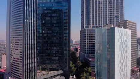 Drone-backwards-group-of-tall-buildings-in-Mexico-city-daylight