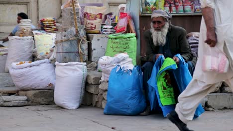 Shot-of-old-man-selling-fertilizer-on-the-side-of-the-road,-Pakistan