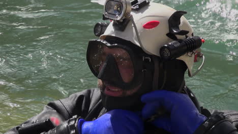 Closeup:-Bearded-tech-scuba-diver-dons-helmet-in-turbulent-river-water