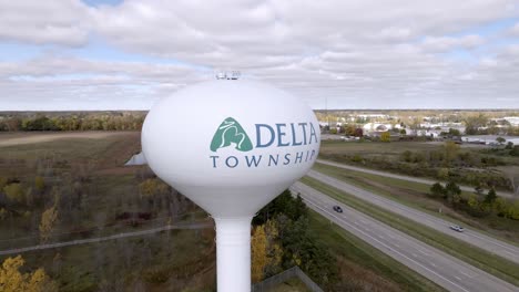 Delta-Township,-Michigan-water-tower-with-drone-video-circling-medium-shot