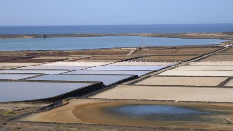 Salinas-de-Danubio,-Salt-flats-in-Lanzarote-landscape-seen-from-the-distance-moving-from-right-to-the-left