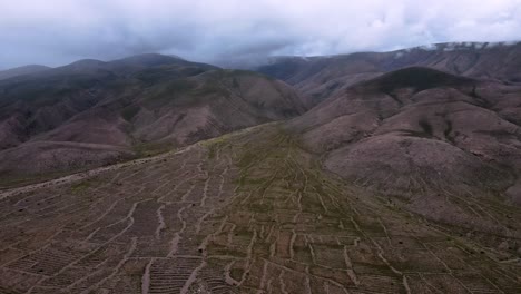 Drohnenschuss-Fliegt-über-Die-Ruinen-Einer-Antiken-Stadt-Und-Ihre-Landwirtschaftlichen-Felder-In-Jujuy,-Argentinien