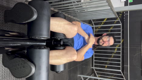 Latin-man-with-beard-and-long-hair-doing-sit-ups-on-incline-bench