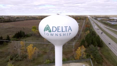 Delta-Township,-Michigan-water-tower-with-drone-video-pulling-back