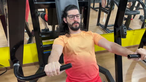 Latin-man-with-beard-and-long-hair-performing-exercise-on-equipment-declined