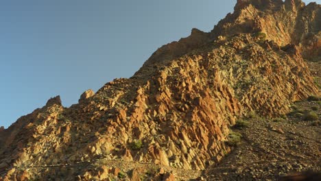Driving-near-the-rocky-mountains-at-Teide-National-Park-on-Tenerife-during-sunset,-pov-closeup-low-angle