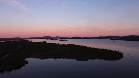 Picturesque-evening-dusk-blue-hour-aerial-over-calm-lake-in-Sweden
