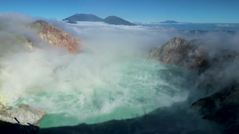 Vista-Panorámica-Aérea-Del-Famoso-Volcán-Ijen-Y-Su-Cráter-ácido-Del-Lago-Azul-Que-Sopla-Humo-En-El-Aire-En-Un-Día-Soleado---Java-Oriental---Indonesia