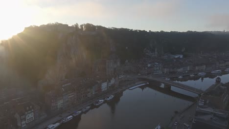 Dinant-Citadel-and-Church-of-Notre-Dame-during-foggy-sunrise,-aerial