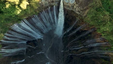bird-eye-view-looking-down-to-Tumpak-Sewu-Waterfall-and-its-hundred-waterfalls-in-a-sunny-morning---East-Java,-Indonesia