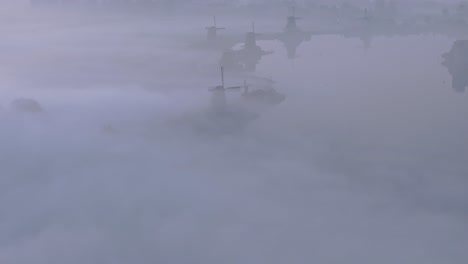 Famous-traditional-Windmills-at-Holland-during-foggy-morning,-aerial