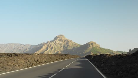 Conduciendo-Por-Una-Carretera-Con-Montones-De-Piedras-A-Lo-Largo-Del-Camino-Hacia-La-Montaña-Durante-La-Puesta-De-Sol,-Pov