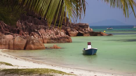 Pequeño-Barco-En-El-Paraíso-Tropical-Del-Océano-De-Seychelles-Con-Playa-En-La-Isla-De-Praslin,-Destino-Turístico