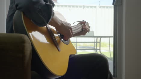 Hombre-Tocando-La-Guitarra-En-Casa