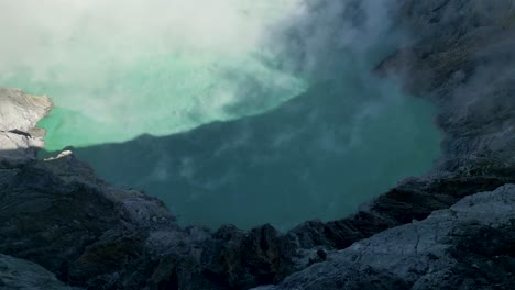 top-view-of-the-blue-acid-lake-in-Ijen-volcano-with-smoke-in-the-air---Banjuwangi---East-Java,-Indonesia