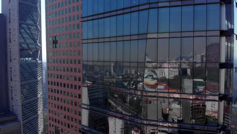 Drone-descending-tall-buildings-in-Mexico-city-reflection-landscape-Colors-daylight