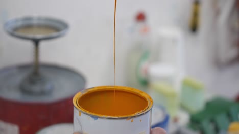 Scraping-dripping-paint-from-paint-pot