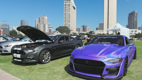 Colourful-cars-at-car-show-with-skyscrapers-in-the-background,-Downtown-San-Diego