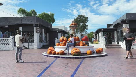 Seaport-Village-San-Diego-Halloween-pumpkins-around-water-fountain,-festive-feel-California