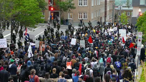 Police-and-army-secure-protest-at-G7-Summit,-crowd-of-people-demonstratively-walking
