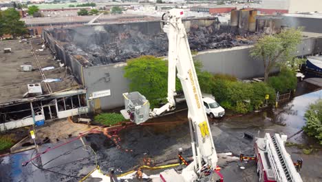 Large-fire-department-crane-near-the-remains-of-a-large-industrial-fire