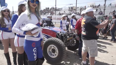 Sponsor-pretty-girls-posing-next-to-a-raid-rally-car-in-Baja-500-race