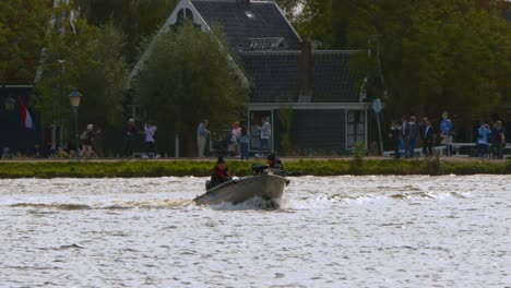 Dutch-Men-Riding-Motorboat-Heading-Out-To-Go-Fishing-In-Amsterdam,-The-Netherlands