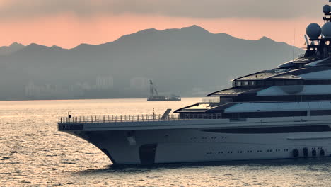 Luxury-Private-Super-Yacht-Anchored-in-Hong-Kong,-Sunset,-Cinematic-Aerial-Close-Up
