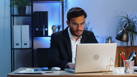 Indischer-Geschäftsmann,-Freiberufler-Am-Büroarbeitsplatz,-Der-An-Einem-Laptop-Computer-Arbeitet,-Sendet-Online-Nachrichten
