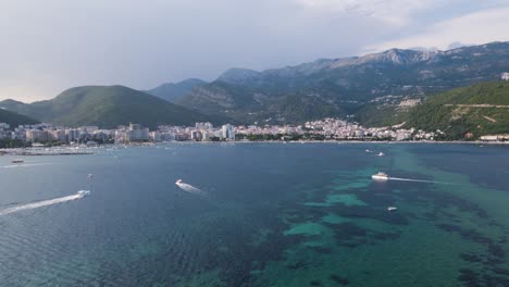 Drone-dolly-shot-toward-Budva-Riviera-with-lots-of-boat-activity,-Montenegro