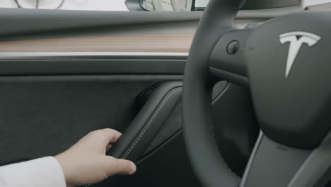 Tesla-Fahrer-öffnet-Die-Tür-Seines-Tesla-Und-Steigt-In-Sein-Auto