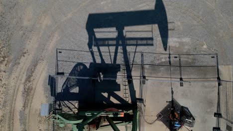 Oil-Pumping-Jack-On-Desert-Sands-In-Summer---aerial-top-down