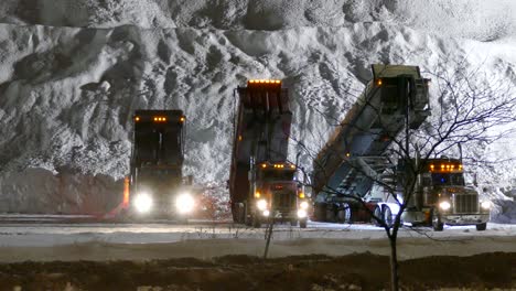 Dump-Trucks-offloading-snow-at-base-of-massive-snow-pile