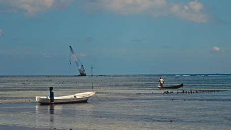 Un-Pescador-Guiando-Su-Barco-Hacia-La-Costa-De-Un-Puerto-Pesquero-En-Bali,-Indonesia.