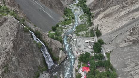 Circular-drone-flying-over-Mantoka-waterfall-in-pakistan-in-Skardu-Looking-over-waterfall-and-people-and-lake-in-beautiful-landscape