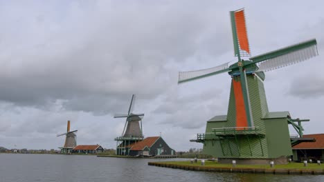 Vista-De-Cerca-De-Los-Molinos-De-Viento-Holandeses-Girando-Contra-El-Cielo-Nublado-En-Amsterdam,-Países-Bajos