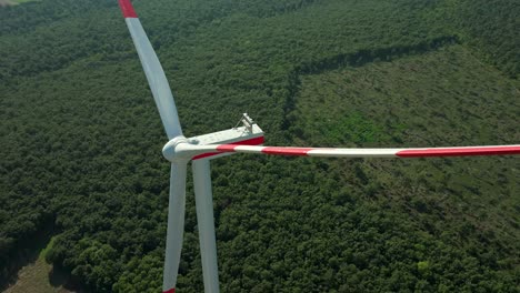 Wind-Turbine-Against-Green-Lush-Field---aerial-close-up