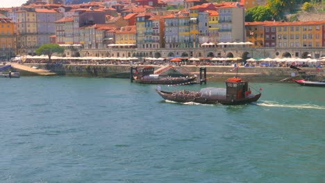 Vista-Panorámica-De-Un-Barco-Con-Turistas-Moviéndose-Por-El-Río-Duero-En-Portugal.