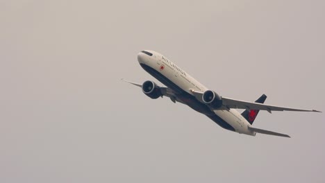 A-close-up-shot-of-an-Air-Canada-Boeing-777-in-mid-flight,-banking-after-taking-off-from-Pearson-International-Airport,-Canada
