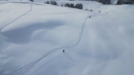 Luftaufnahme-Einer-Jungen-Sportgruppe,-Die-Den-Schneebedeckten-Gletscherhang-In-Verschneiter-Alpenlandschaft-Hinunterfährt,-Blick-Von-Oben-Nach-Unten