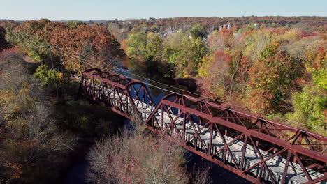 The-Trail-Truss-Bridge-in-West-Warwick-among-the-forests-in-fall-colors,-Rhode-Island