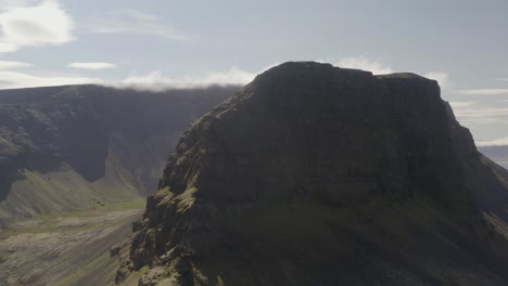 Drone-video-pulling-out-from-the-massive-Svalvogar-mountain-in-Iceland-and-a-bright-sunny-summer-day