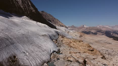 Glacier-in-mountains-ponds-puddles-descending-aerial