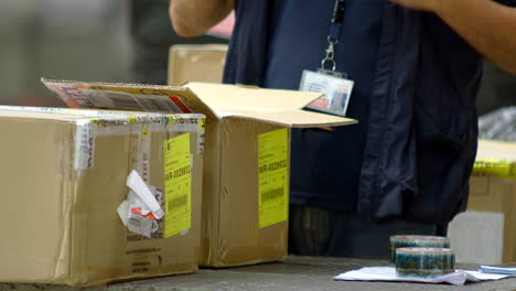 shot-of-man-opening-cardboard-box-for-inspection,-customs