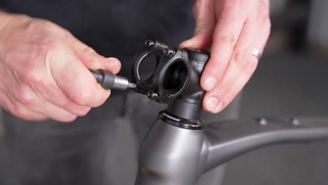 Bike-mechanic-taking-apart-road-bicycle-stem-for-servicing